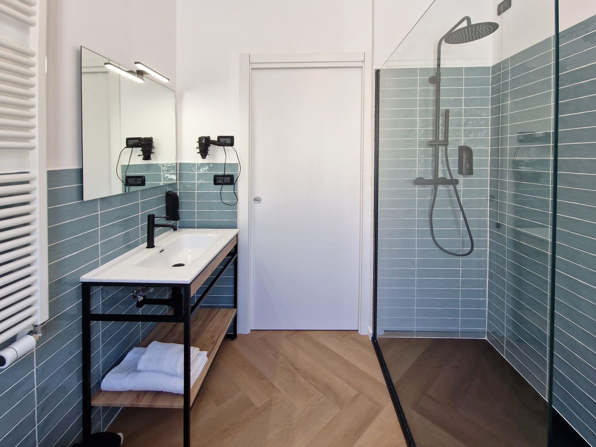 Ein modernes Badezimmer mit Waschbecken, Spiegel und Dusche.