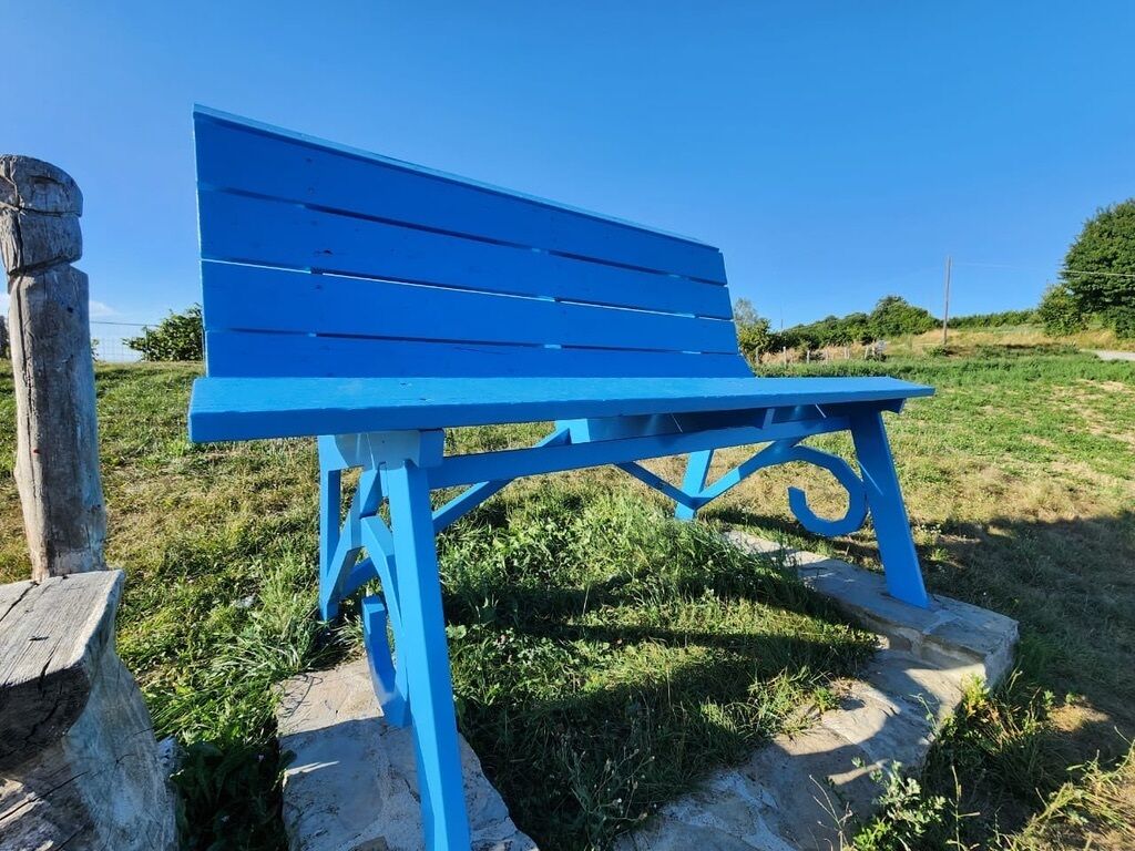 Een blauwe bank in een gazon.