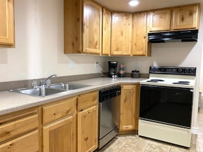 Full kitchen with a range, dishwasher, and coffee maker