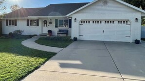 A single-story house with a garage, a front porch, and a well-maintained lawn. - Friends & Family Retreat|Epic Game Room|Pets too (Orem)