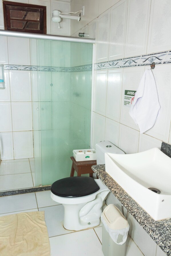 A bathroom with a toilet, sink, and shower.
