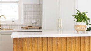 A modern kitchen with white cabinetry, a wooden countertop, a sink, and a potted plant. - Cove Cottage South West Rocks (South West Rocks)