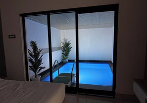 Une pièce dotée d’une grande porte-fenêtre coulissante donnant sur un espace piscine.
