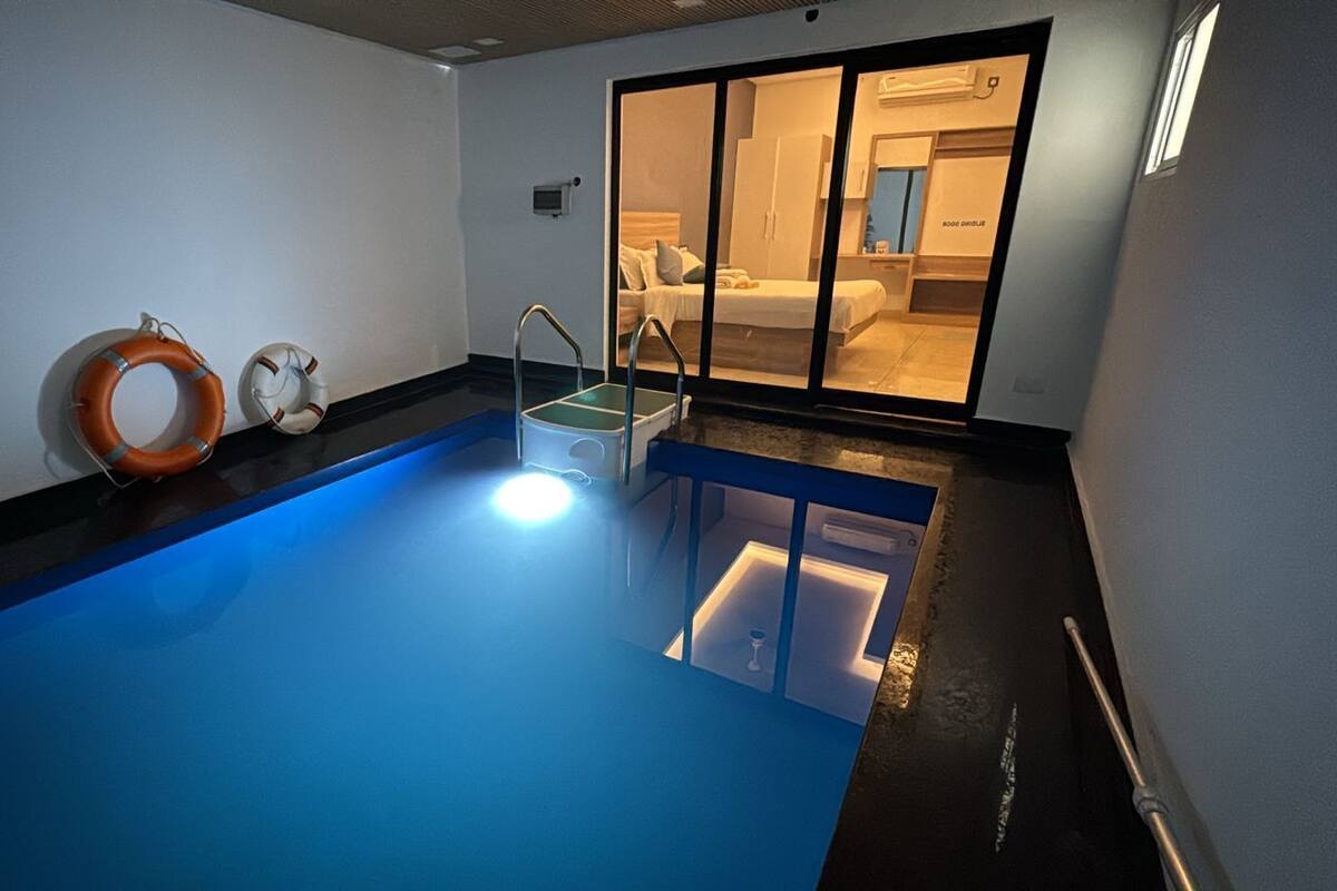 Une piscine avec un fond bleu, une échelle et une bouée de sauvetage.