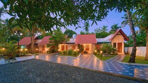 A resort with multiple buildings, a gravel driveway, and well-maintained landscaping. - Sarang Resort Varkala by VOYE HOMES (Varkala)