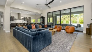 A modern living room with a sectional sofa, a coffee table, and two armchairs. - Luxury in North Scottsdale sleeps 10 (Scottsdale)