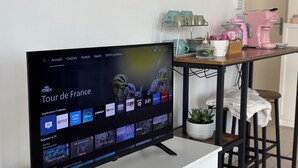 A television displaying a streaming service interface with various apps and a menu bar.