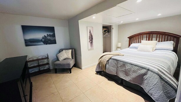 A bedroom with a bed, a chair, a desk, and a painting on the wall. - 1 bedroom apartment, centrally located and newly renovated (Moncton)
