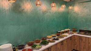 A buffet setup with various food items and a long counter. - Karasu Riva Otel (Karasu)