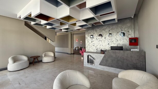 A modern hotel lobby with a reception desk, seating area, and a staircase. - Karasu Riva Otel (Karasu)