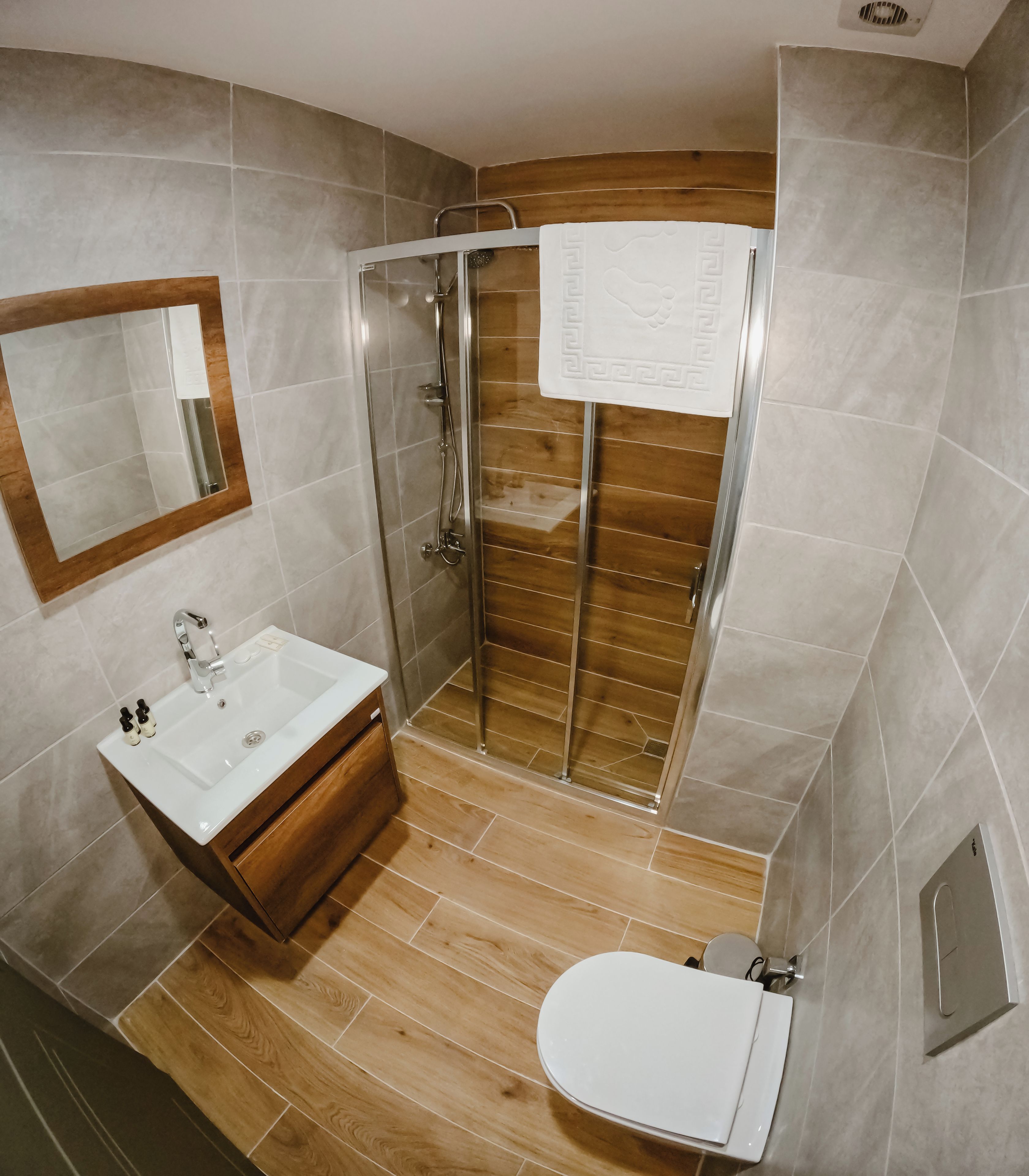 A bathroom with a shower, sink, and toilet.