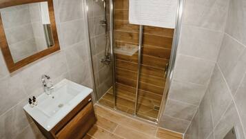 A bathroom with a shower, sink, and toilet.