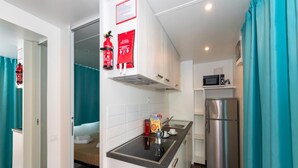 A compact kitchen with a microwave, stainless steel refrigerator, and a small sink. - The Garda Village Caravan Park, Sirmione (Sirmione)