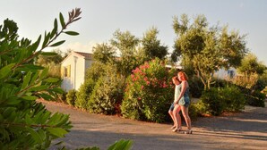 A residential area with a house, a driveway, and a person walking. - Mobile Home in Bessan With Terrace (Bessan)