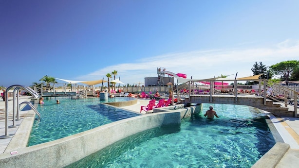A large outdoor swimming pool with multiple lanes, a water slide, and lounge chairs. - Mobile Home in Serignan With Great Pool Area (Sérignan)