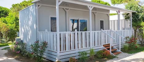 A white single-story building with a covered porch and a small set of stairs leading to the entrance.