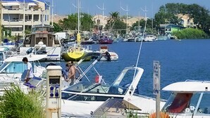 A marina with various boats docked, a swimming pool, and buildings in the background. - Mobile Home Prestige With air Conditioning (Sérignan)
