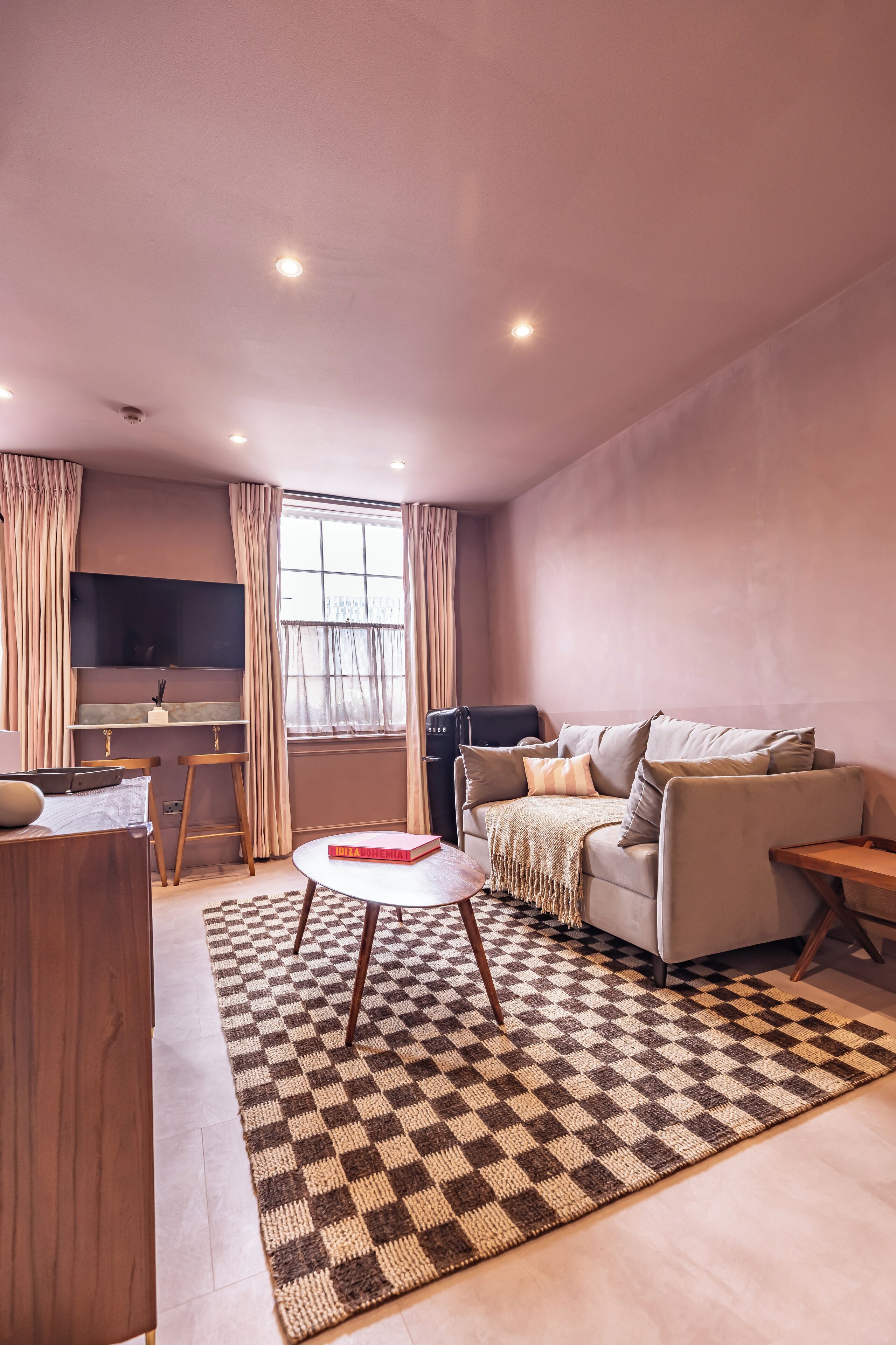 Una sala de estar moderna con un sofá, una mesa de centro y un televisor montado en la pared.