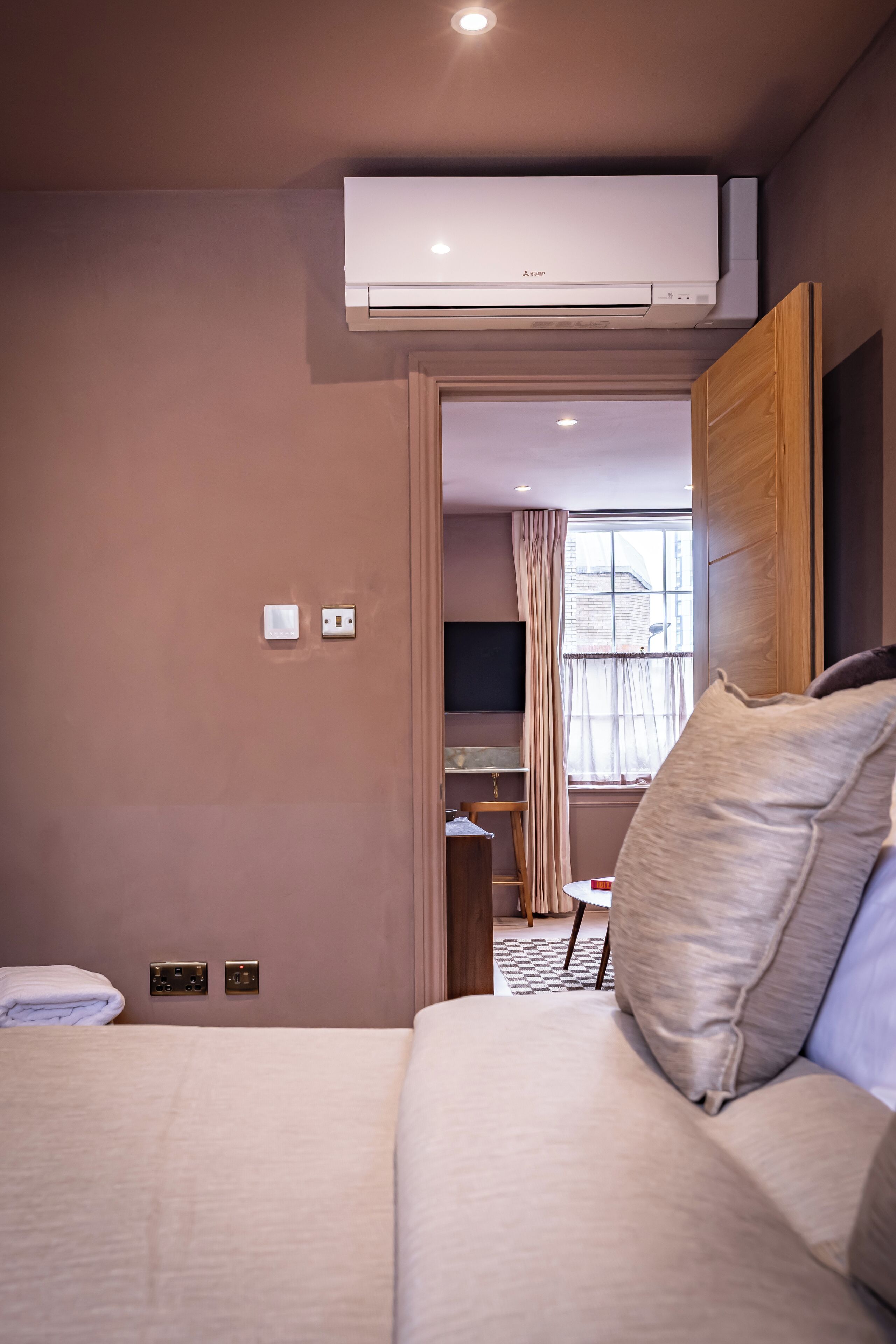 A hotel room with a bed, a desk, and a television.