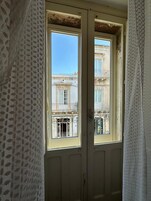 Una habitación con un ventanal que da a un edificio con balcones.