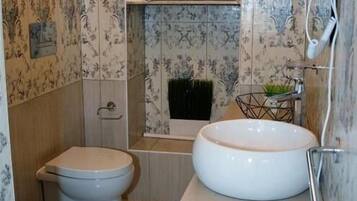 Ein modernes Badezimmer mit Toilette, Bidet und einem großen Waschbecken.