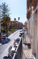 Una calle estrecha con coches aparcados y edificios a ambos lados.