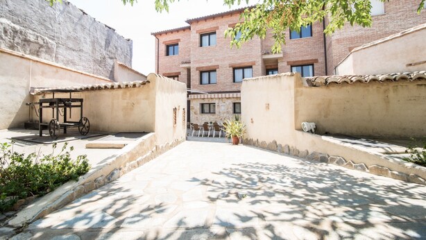 A courtyard with a brick building, a bicycle, and a potted plant.