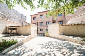 A courtyard with a brick building, a bicycle, and a potted plant.