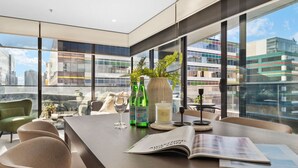 A modern conference room with large windows, a glass table, and a view of the cityscape.