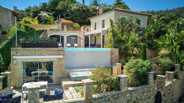 A modern villa with a swimming pool, outdoor seating, and lush greenery. - Upstays Sea View Pool 250m² Villa (Vallauris)