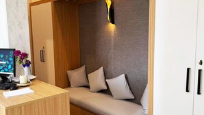 A room with a wooden desk, a computer, a vase with flowers, a sofa with cushions, and a wardrobe. - 3-bedroom bed & breakfast in enjoyable Cairo Governorate with AC (Cairo Governorate)