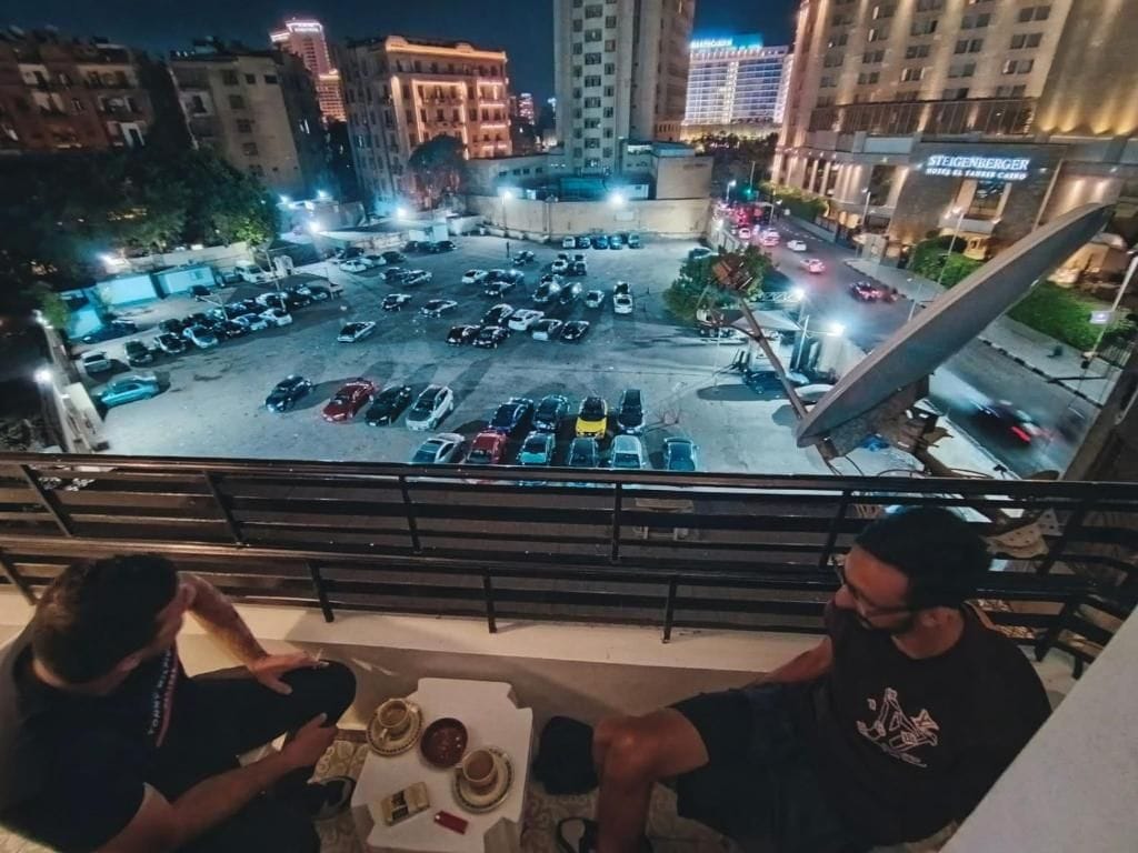 A rooftop terrace with a view of a parking lot and cityscape.