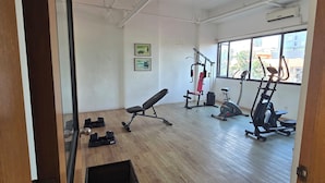 A gym with exercise equipment, wooden flooring, and large windows. - Studio Unit Condo near Ayala Center Cebu w/Netflix & Fast Wifi
(Ohana Suites#1) (Cebu City)