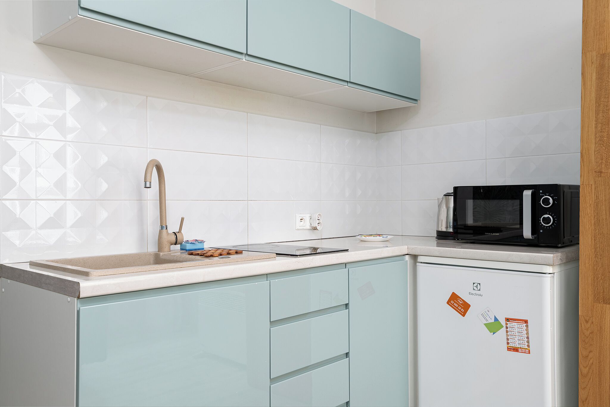 Una cocina compacta con un lavabo, un microondas y un refrigerador.