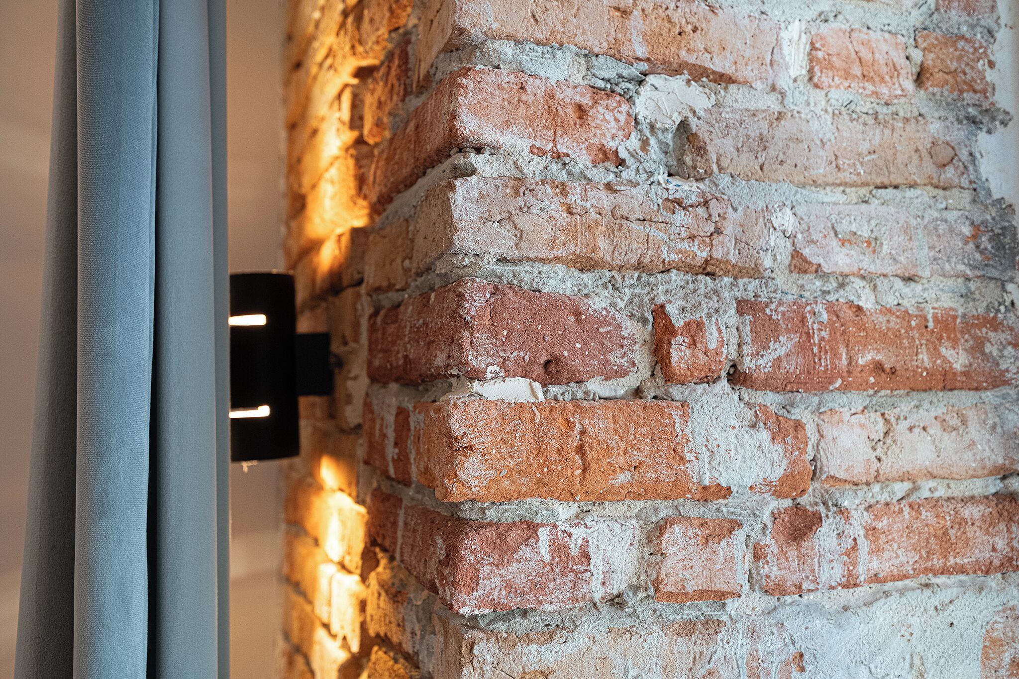A close-up of a brick wall with a metal fixture.