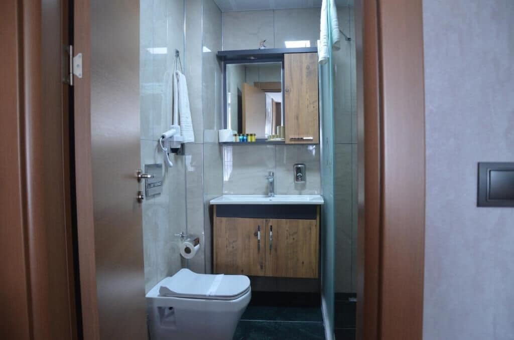 Un baño pequeño con inodoro, lavamanos y espejo.