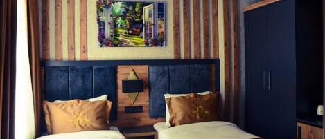 A hotel room with two beds, a large painting above the headboard, and wooden paneling on the walls.