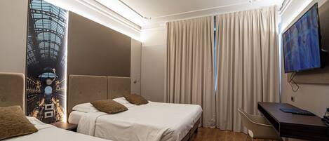 A hotel room with two beds, a desk, a chair, a TV, and a large window with curtains.