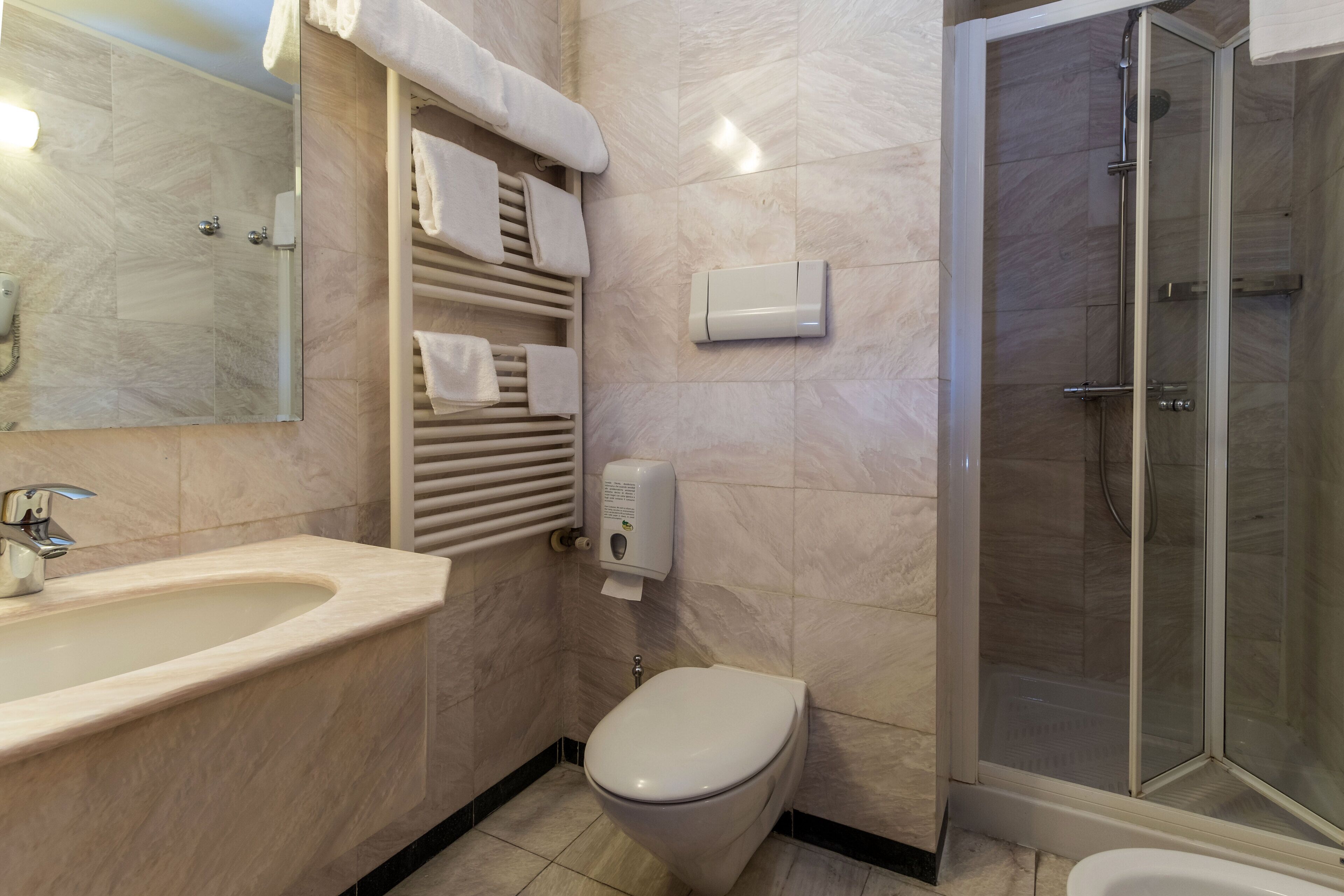 A modern bathroom with a sink, toilet, and shower.