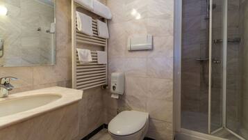 A modern bathroom with a sink, toilet, and shower.
