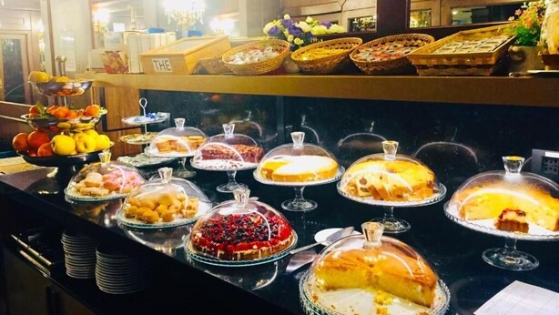Un bufé con diversos postres y frutas.