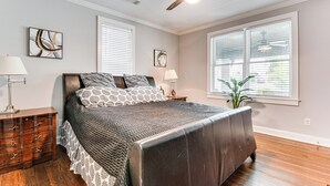 A bedroom with a bed, wooden dresser, ceiling fan, and large windows. - 4 Mi to Dtwn: Relaxing Escape w/ Yard in Atlanta (Atlanta)