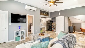 A modern living room with a white sofa, a coffee table, and a TV. - 'the Penthouse' in Space City: 10 Mi to NRG (Houston)
