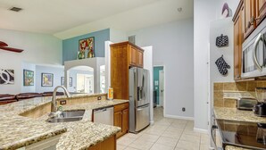 A modern kitchen with granite countertops, stainless steel appliances, and wooden cabinets. - Family Home in Port St Lucie w/ Furnished Pergola! (Port Saint Lucie)