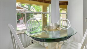 A round glass table with two white chairs, a woven basket, and a window with blinds. - Family Home in Port St Lucie w/ Furnished Pergola! (Port Saint Lucie)