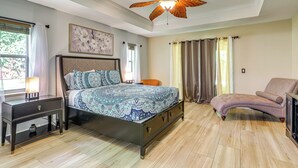 A bedroom with a bed, nightstand, chair, and ceiling fan. - Family Home in Port St Lucie w/ Furnished Pergola! (Port Saint Lucie)