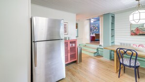 A kitchen with a stainless steel refrigerator, a pink cabinet, a wooden table, and a blue chair. - Walk to Bars, Bites + Bands: Bold Athens Getaway! (Athens)