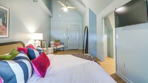 A bedroom with a bed, pillows, a chair, a desk, and a door. - Walk to Bars, Bites + Bands: Bold Athens Getaway! (Athens)