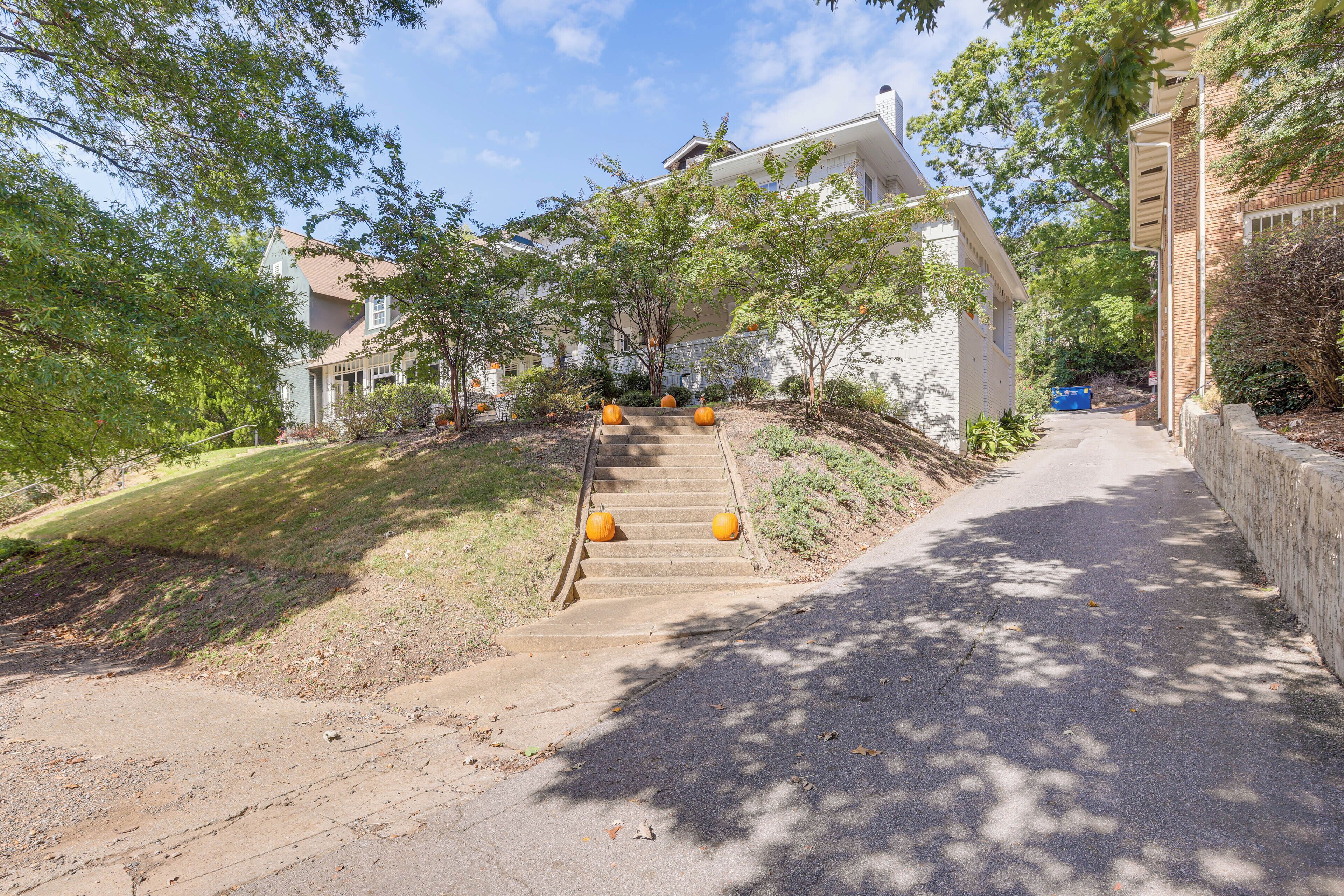 A residential street with a house, a sidewalk, and a driveway.