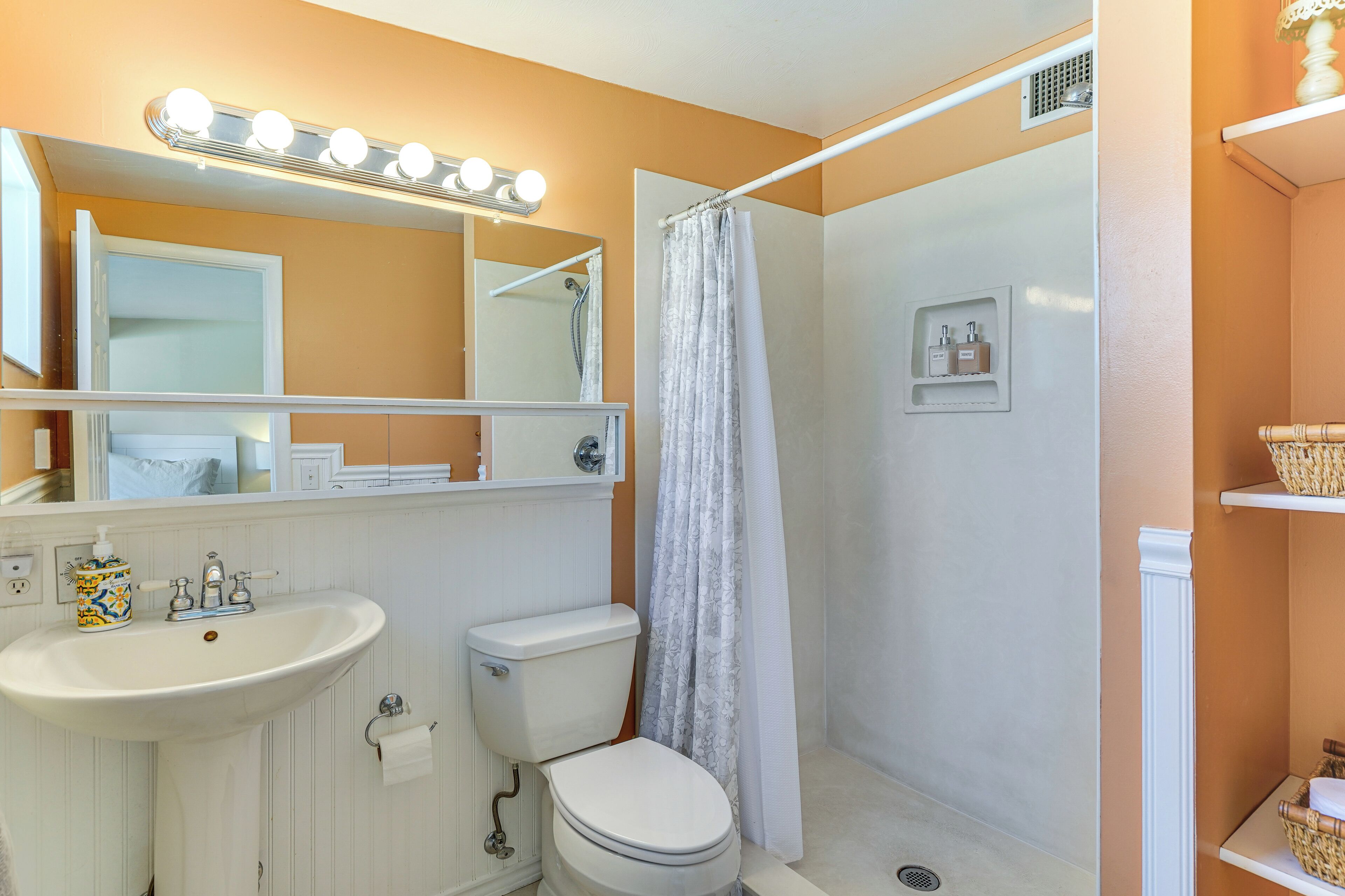 Un baño con lavamanos, inodoro y ducha.